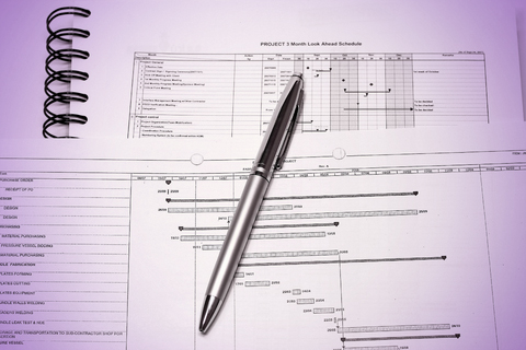 Close up picture of a pile of system studies and analysis with a smart silver pen in the middle of the picture