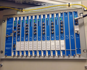 A blue and white electrical panel with wires hanging from the ceiling.