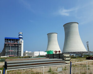 A large white power plant with three towers.
