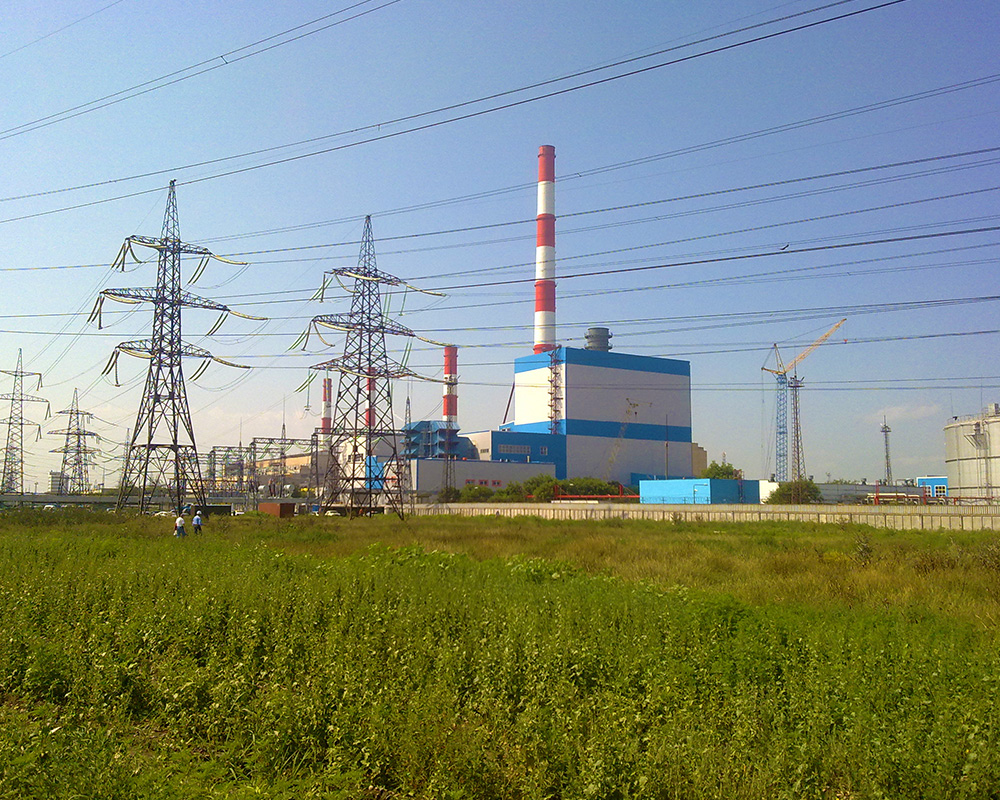 A power plant with many towers and wires.