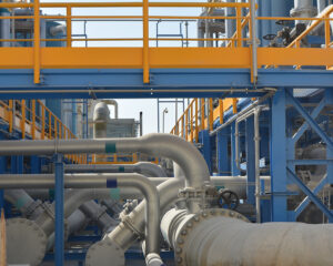 A large industrial plant with pipes and blue and yellow structures.