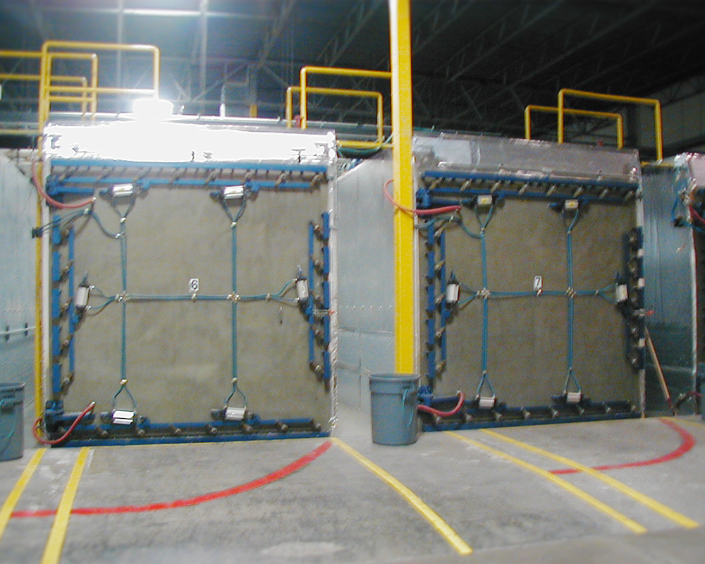 Two large concrete panels in a warehouse with wires.