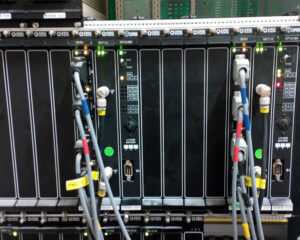 A rack of servers with some wires hanging from them.