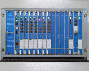 A blue and silver computer board with many buttons.